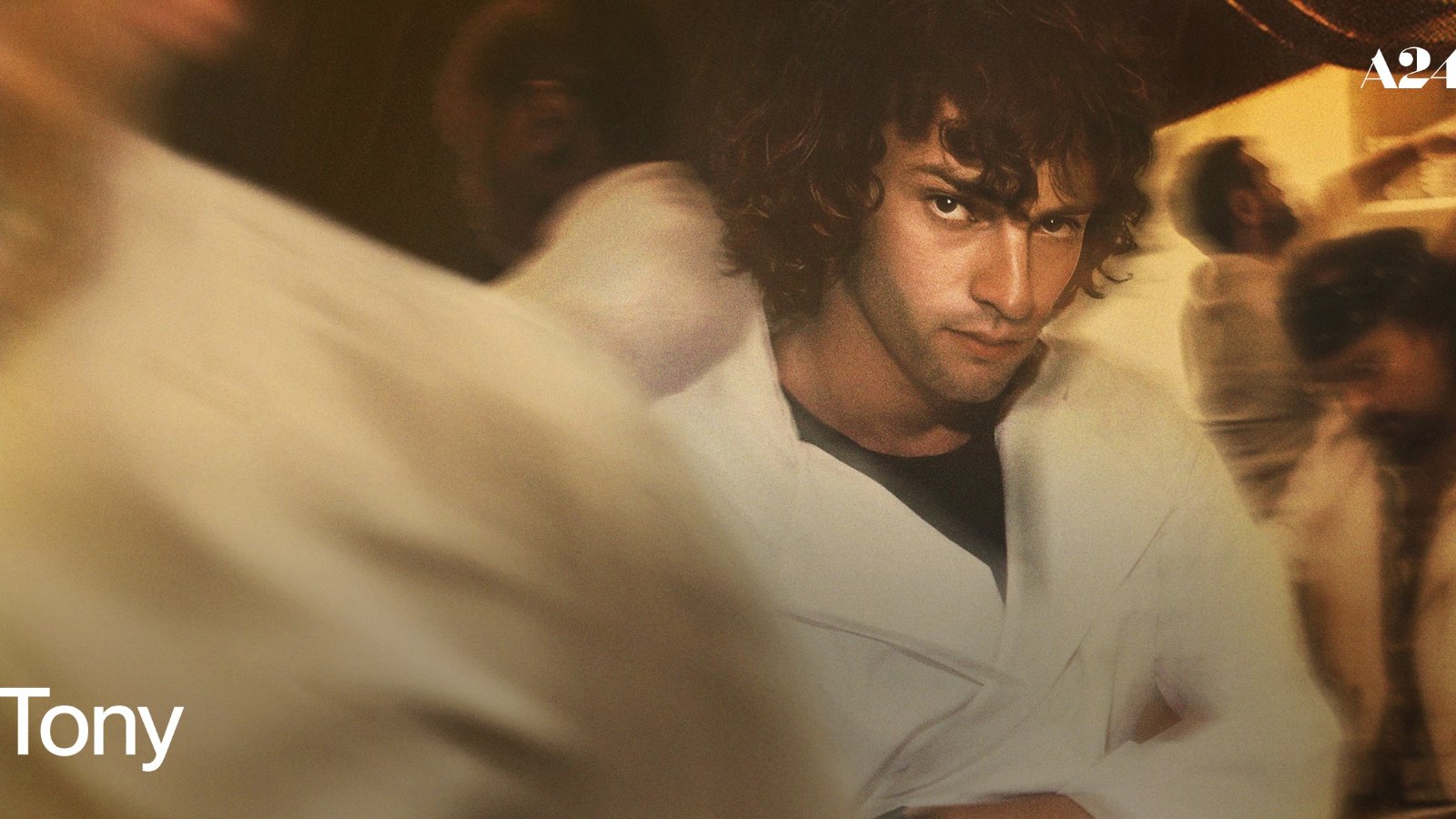 Dominic Sessa interpreta Anthony Bourdain na juventude em “Tony”. Texto alternativo: Dominic Sessa veste uniforme branco de cozinha na arte promocional de “Tony”.